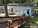 Single-story home with patio, stairs and surrounding trees at 108 Meadowview Cir, New London, NC 28127