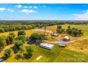Aerial view showing home, large barn, pond and surrounding land at 11681 Mooresville Rd, Davidson, NC 28036