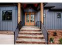 Front entry with stone steps and modern railings at 116 Emmaline Ct, Troutman, NC 28166