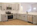 Modern kitchen with gray cabinets and stainless steel appliances at 5348 Almeda Pl, Concord, NC 28027