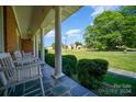 Covered porch with stone flooring and white chairs at 1418 Oakwood Ave, Kannapolis, NC 28081