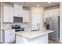 Modern kitchen with white cabinets, stainless steel appliances, and quartz countertops at 3820 Shider Ln, Kannapolis, NC 28081