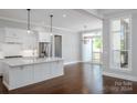 Open kitchen with white cabinets, large island, and hardwood floors at 00 Rivendell Rd # 7, Denver, NC 28037