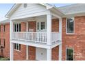 Brick house with a white balcony featuring rocking chairs at 4299 Randleman Rd, Iron Station, NC 28080
