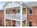 Brick house with a white balcony featuring rocking chairs at 4299 Randleman Rd, Iron Station, NC 28080