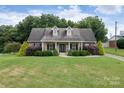 Brick home with a covered front porch and landscaping at 114 Market St, Rockwell, NC 28138