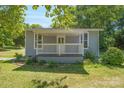 Gray house with a white porch and well-maintained lawn at 1021 Wall St, Statesville, NC 28677