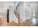 Bright entryway with hardwood floors, staircase, and view into kitchen at 205 W Phifer St, Monroe, NC 28110