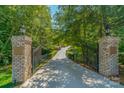 Long driveway entrance with brick pillars and a wrought-iron gate at 1008 Medinah Ct, Waxhaw, NC 28173