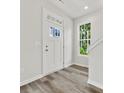 Bright entryway with white door, wood-look floors, and stairway at 1008 Ribbon Ln, Charlotte, NC 28205
