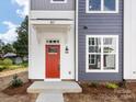 Townhome's front entrance with red door and gray siding at 1008 Ribbon Ln, Charlotte, NC 28205