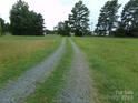 Gravel driveway leading to a house in a rural setting at 14004 Elm St, Stanfield, NC 28163
