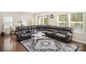 Spacious living room featuring hardwood floors, sectional sofa, and large windows at 168 Ravensara Ave, Fort Mill, SC 29715