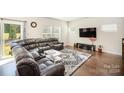 Living room with hardwood floors, sectional sofa, and access to backyard at 168 Ravensara Ave, Fort Mill, SC 29715
