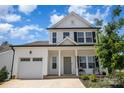 Two-story white house with gray roof, front porch, and attached garage at 29060 Low Country Ln, Lancaster, SC 29720