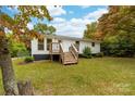 Updated white ranch home with a welcoming deck and steps leading to the entrance at 115 E Georgia Ave, Bessemer City, NC 28016