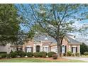 Two-story brick home with manicured lawn and large tree at 17813 Spinnakers Reach Dr, Cornelius, NC 28031