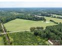 Aerial view of expansive land with pond and road at 12136 Renee Ford Rd, Stanfield, NC 28163
