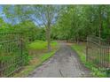 Long driveway with wrought iron gates leading to home at 15610 Youngblood Rd, Charlotte, NC 28278