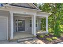 Front porch of a two-story house with gray siding and white columns at 126 Meadow Glen Dr, Troutman, NC 28166