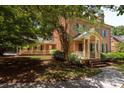 Two-story house with brick facade, front porch, and mature trees at 9808 Warwick Cir, Charlotte, NC 28210