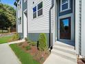 Townhome entrance with dark brown door, gray siding, and landscaping at 8009 Elevate Ct, Charlotte, NC 28205