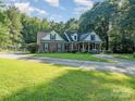 Brick and white home with covered porch and landscaping at 10227 Mount Holly Rd, Charlotte, NC 28214