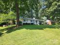 Ranch home with a lush green lawn and mature trees at 5328 Seacroft Rd, Charlotte, NC 28210