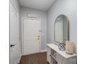 Bright entryway with white door, wood floors, and decorative console table at 17135 Red Feather Dr, Charlotte, NC 28277