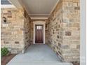 Inviting front entry with stone facade and a dark wood front door at 1346 Millview Ln, Matthews, NC 28104