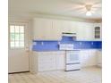 Bright kitchen with white cabinets, blue countertops, and white appliances at 452 Mocksville Hwy, Statesville, NC 28625