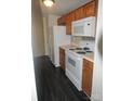 Kitchen features wood cabinets, laminate flooring, and white appliances at 1600 H Arlyn Cir, Charlotte, NC 28213