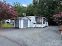 Mobile home with shed and screened porch, surrounded by trees at 113 Hummingbird Cir, New London, NC 28127