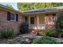 Front porch of a brick house with steps and surrounding plants at 1890 Rhyneland Rd, Lincolnton, NC 28092