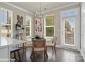 Bright dining area with glass table and woven chairs, adjacent to kitchen and backyard access at 3022 Loso Ter # 52, Charlotte, NC 28217