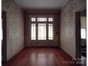 Front entry with hardwood floors and floral wallpaper at 222 Leak Ave, Wadesboro, NC 28170