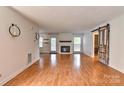 Spacious living room with hardwood floors, fireplace, and sliding barn door at 13901 Phillips Rd, Matthews, NC 28105
