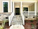 Inviting front porch with stone steps and railing at 310 Scalybark Trl, Concord, NC 28027