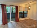 Dining area with hardwood floors, sliding glass doors, and red curtains at 7201 Winery Ln, Charlotte, NC 28227