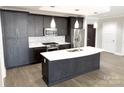 Modern kitchen with island, stainless steel appliances, and dark cabinetry at 222 S Caldwell St # 1801, Charlotte, NC 28202