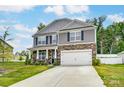 Two-story house with gray siding and stone accents at 208 Wildflower Dr, Locust, NC 28097