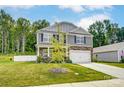 Two-story home with stone accents and a landscaped lawn at 208 Wildflower Dr, Locust, NC 28097
