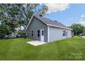 Gray house with a small patio and grassy backyard at 920 Holmes St, Salisbury, NC 28144