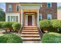 Brick front exterior of charming home with a welcoming porch and lush landscaping at 6517 Hunter Pine Ln, Charlotte, NC 28270