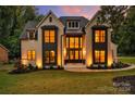 Elegant two-story home illuminated at night, showcasing its architectural details and landscaping at 3500 Barclay Downs Dr, Charlotte, NC 28209