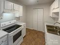 Bright kitchen with white cabinets, stainless steel sink, and electric range at 4432 Eaves Ln, Charlotte, NC 28215