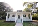 Front view of a charming white house with a porch at 615 English St, Monroe, NC 28110