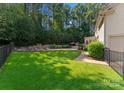Landscaped backyard with a stone retaining wall and artificial turf at 124 Streamwood Rd, Troutman, NC 28166