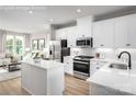 Open concept kitchen with white cabinets, island, and stainless steel appliances at 2829 Statesville Ave, Charlotte, NC 28206