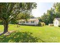 Ranch-style home with a teal front door and large tree in front at 2005 Hilton Way Rd, Lancaster, SC 29720